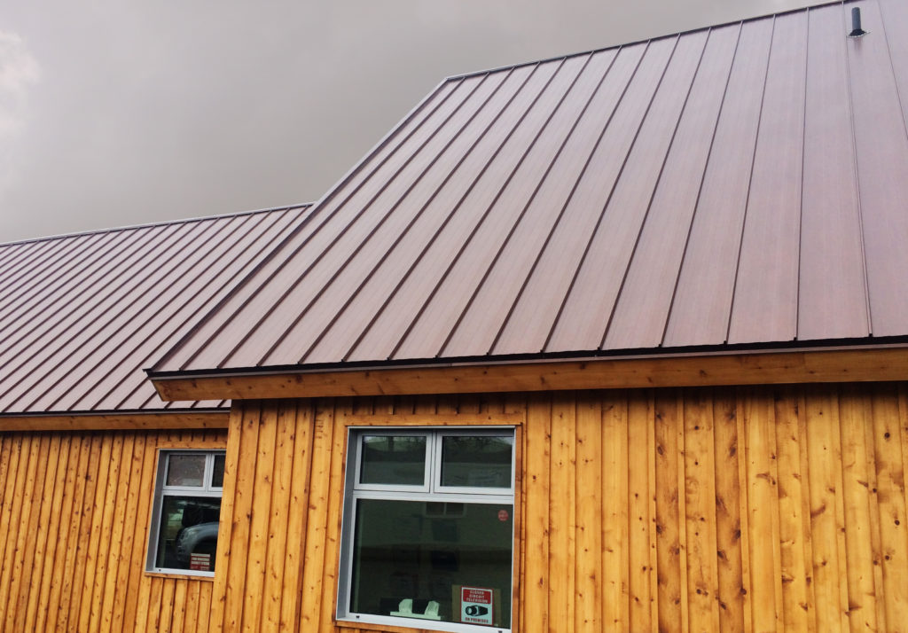 Burgundy toned rustic red hidden fastener roofing panel on a cedar building in Kenora Ontario